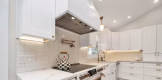 Top Kitchen Cabinet Colors 2026 That Boost Home Value Warm mushroom painted kitchen cabinets with brass hardware in a modern home