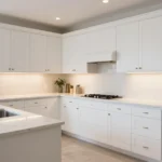 What Is Cabinet Refacing And Is It Worth It Wide shot of a bright modern transitional kitchen featuring updated shaker cabinets and clean quartz countertops